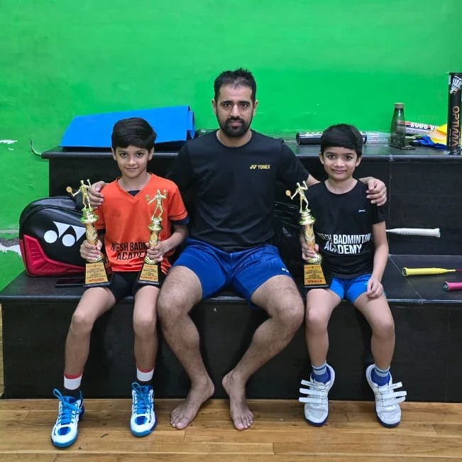 Coach Nitesh with junior tournament trophy winners at Nitesh Badminton Academy